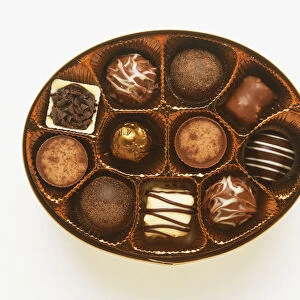 Open oval box of chocolates, view from above