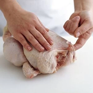 Using fingers to remove wishbone from chicken, close-up