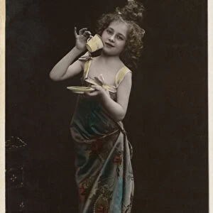 Little girl dressed up drinking tea (colour photo)