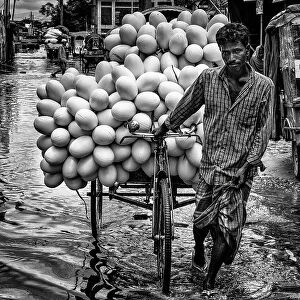 Carrying goods through flooded streets in Bangladesh