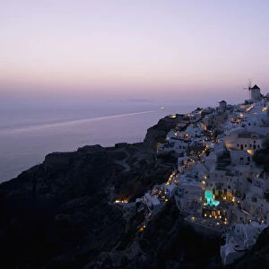 An Aerial View Of Oia And The Windmill At Dusk; Oia, Santorini, The Cyclades, The Aegean, The Greek Islands, Greece