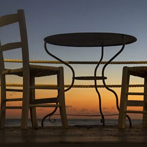 A Table And Chairs On A Patio With A View Of A Colourful Sunset; Paphos, Cyprus