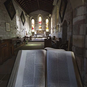 View Of The Interior Of A Church With Stained Glass Windows And An Open Bible; Bamburgh, Northumberland, England