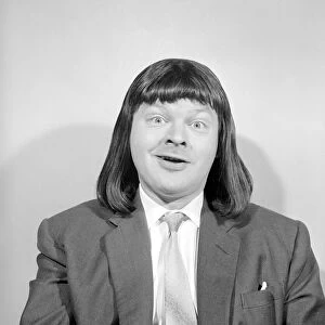 Comedian Benny Hill pictured at home wearing a wig May 1958