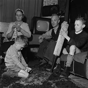 Family Life in Oldham 1952. Mother sews while father watch his youngest son play