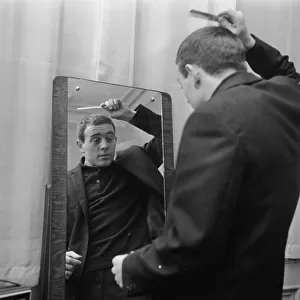 Liverpool player Ian St John looks in the mirror to comb his hair as he gets ready for