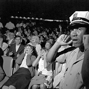 A Policeman puts his fingers in his ears to block out the noise as the Beatles perform