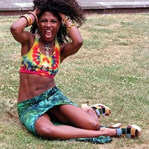 SINITTA SITTING IN PARK WITH HER HANDS IN HER HAIR IN PROMOTIONAL HAIR PHOTOCALL