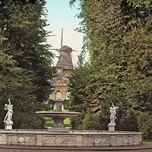 The fountain of Sans-Souci Palace park, with the old mill in the background, Potsdam, Germany